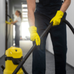 Büroreinigung. Teppichreinigung mit professionellen Staubsauger und Handschuhe für Hygiene